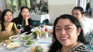 Song CauRUBEACH HOTEL & REROST的一群坐在餐桌上吃食物的妇女