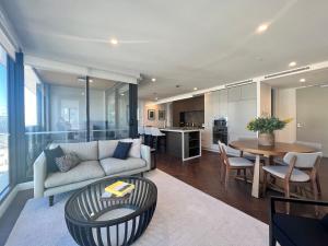 墨尔本Samma Flagstaff Luxury Apartments的客厅配有沙发和桌子