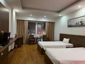 清化Phù Đổng Hotel Thanh Hóa的酒店客房设有两张床和电视。