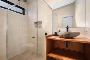 布赖特White Star Lodge的一间带水槽和玻璃淋浴的浴室