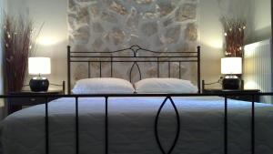 卡斯托里亚戴尔拉戈别墅精品酒店的一间卧室配有一张带两盏灯的床。