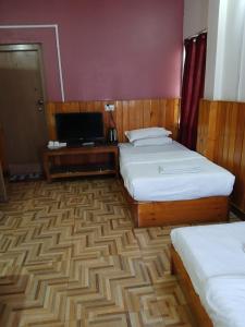 PajoTashi Yarphel的酒店客房设有两张床和一台平面电视。