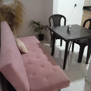 麦德林Hostel Campoamor的客厅配有粉红色的沙发和桌子