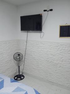 麦德林Hostel Campoamor的挂在墙上的平板电视,配有风扇