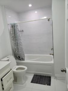 布兰普顿Langston Beautiful Home的白色的浴室设有卫生间和浴缸。