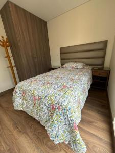 利马LA POSADA de GUILLE - LUXURY APARTS NEXT TO USA EMBASSY的一间卧室配有一张带五颜六色棉被的床