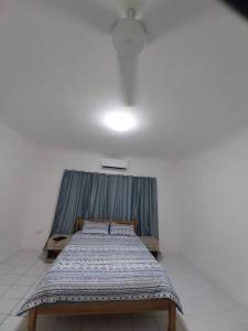 霍尼亚拉Harbour View House at Point Cruz, Honiara的蓝色窗帘的房间的一张床位