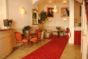 奈梅亨Hotel De Gulden Waagen的走廊上设有桌椅和红色地毯