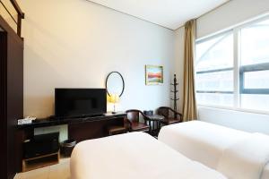 首尔城际首尔酒店 的酒店客房配有一张床和一张带镜子的书桌