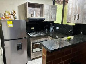 贝约Apartamento en Bello Medellín的厨房配有不锈钢冰箱和炉灶。