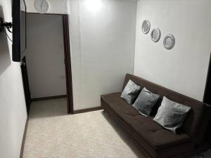 贝约Apartamento en Bello Medellín的客厅配有带2个枕头的棕色沙发