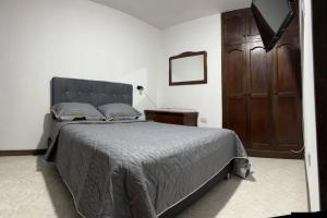 贝约Apartamento en Bello Medellín的一间卧室配有一张大床和一个木制橱柜