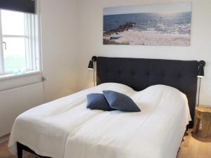 伦讷4 person holiday home in R nne的一间卧室配有一张带蓝色枕头的床