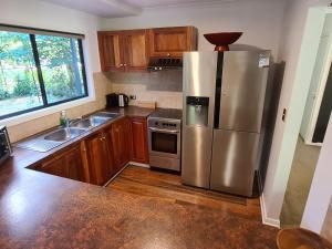 布赖特Rail Trail Cottage - Bright的厨房配有不锈钢冰箱和木制橱柜