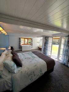 科罗曼德镇4 Palms Cottage Coromandel Town的一间带一张大床的卧室,位于带窗户的房间内