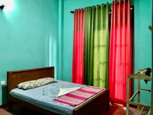 MahoLucky's Homestay的一间卧室配有绿色和红色的窗帘和床