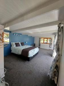 科罗曼德镇4 Palms Cottage Coromandel Town的蓝色客房中一间带床的卧室