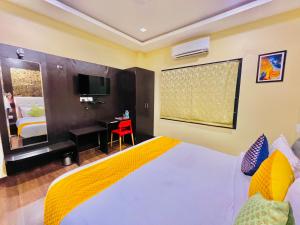 乌代浦Hotel Grand Bhagwat, Udaipur的一间卧室配有一张床、一张书桌和一台电视