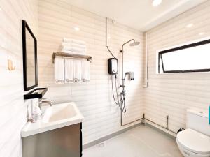 新加坡K2 Guesthouse的带淋浴和盥洗盆的白色浴室