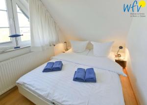 于斯德Luv und Lee Ferienwohnung Dornbusch的一间卧室配有一张带蓝色拖鞋的床。