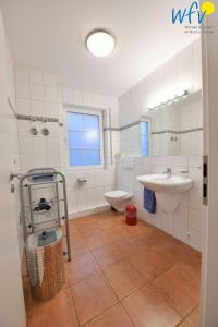 于斯德Luv und Lee Ferienwohnung Pilsum的浴室配有盥洗盆、卫生间和盥洗盆。