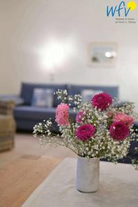 于斯德Luv und Lee Ferienwohnung Westerhever的客厅里白色花瓶,有粉红色的花朵
