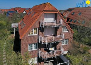 于斯德Luv und Lee Ferienwohnung Westerhever的公寓大楼的一侧设有阳台。