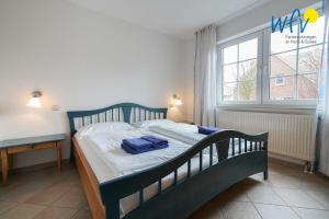 于斯德Luv und Lee Ferienwohnung Flügge的一间卧室配有一张床、一张书桌和一个窗户。