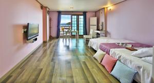 统营市Paper island pension的酒店客房设有两张床和电视。