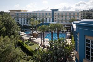 亚里索维耶荷阿里索维耶荷俱乐部运动万丽酒店的享有带游泳池和棕榈树的度假村的景致