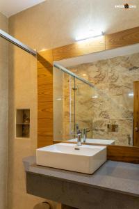 勒克瑙The Ecstasy Hotel的浴室设有白色水槽和镜子