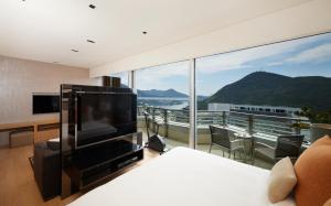 香港Nina Hotel Island South的一间带电视和大窗户的卧室