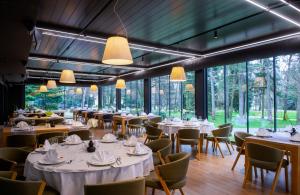 瓦拉日丁帕克精品酒店的餐厅设有桌椅和大窗户。