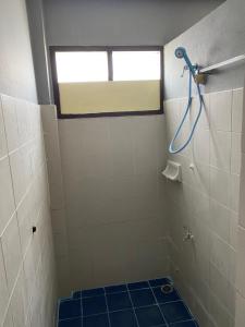 甲米镇Saran Hostel krabi Thailand的浴室设有淋浴、窗户和蓝色瓷砖地板。