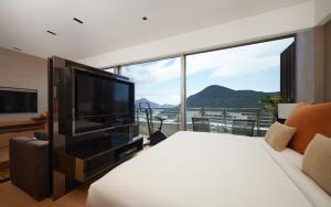香港Nina Hotel Island South的一间卧室设有大电视和大窗户
