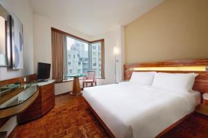 香港铜锣湾如心酒店的酒店客房设有一张白色大床和一张书桌