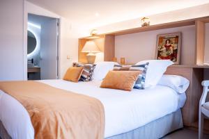 莫奈斯Hotel Monells Summum的卧室配有带枕头的大型白色床