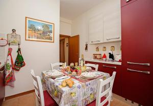 代森扎诺-德尔加达Villa Mimosa - Appartamento 1 - Happy Rentals的厨房配有餐桌和食物