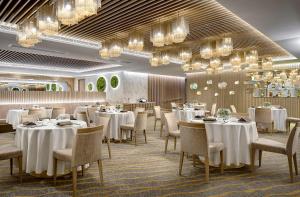 香港铜锣湾如心酒店的餐厅设有白色的桌椅和吊灯。