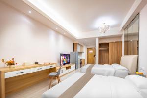 成都娅遇国际酒店公寓(新会展中心店)的酒店客房设有一张床、一张书桌和一台电视机。