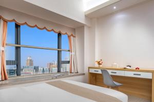 成都娅遇国际酒店公寓(新会展中心店)的一间卧室设有一张桌子和一个大窗户