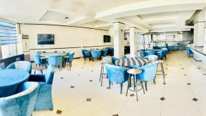 安曼Panorama Amman Hotel的一间配备有蓝色椅子和桌子的用餐室