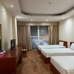 清化Phù Đổng Hotel Thanh Hóa的酒店客房设有两张床和窗户。