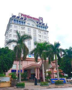 清化Phù Đổng Hotel Thanh Hóa的一座高大的建筑,前面有棕榈树