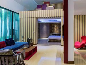 台东欧游国际连锁精品旅馆 - 台东馆的一间带一张床的客厅和一间带沙发的房间