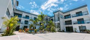南迪Ocean Breeze Apartment的一座白色的建筑,前面有棕榈树