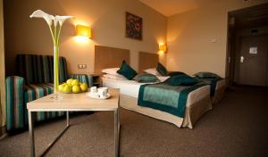 圣君士坦丁和海伦那Azalia Beach Hotel Balneo & SPA的酒店客房设有两张床和一张桌子。