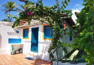 MaxaranguapeCabanas Caraúbas的白色的房子,拥有蓝色的窗户和鲜花