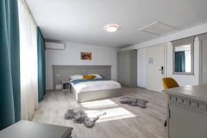 Sub CoastăSky Rooms by Volo Guest House的卧室配有一张床和一张桌子及椅子