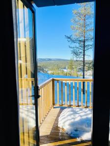 伊德勒The Riverside Mountain Lodge - 110sqm of Calm Luxury的从带雪的甲板的玻璃门上欣赏美景